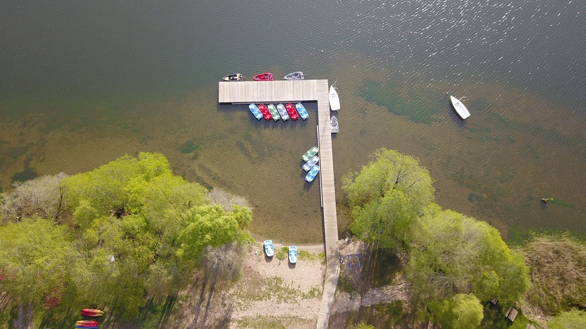 Przystań z kajakami przy drewnianym molo na jeziorze, widok z drona