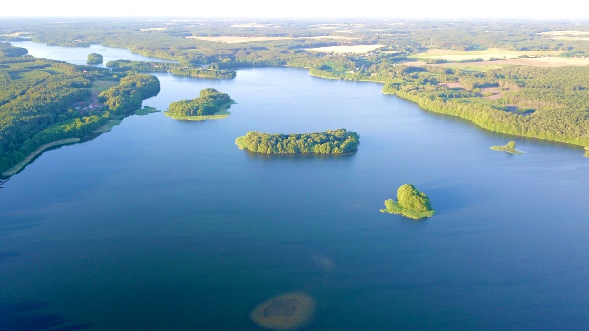 Jezioro z chainą małych zalesionych wysp, widok z drona